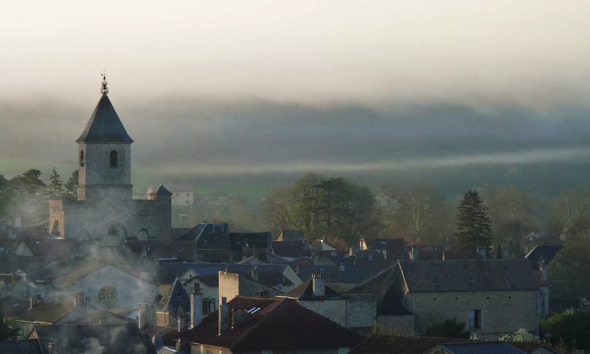 Abbatiale Saint-Pierre de Nant au petit matin embrumé.